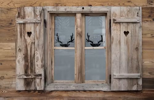 Véranda avec fenêtres en bois blanc, vue sur un jardin verdoyant